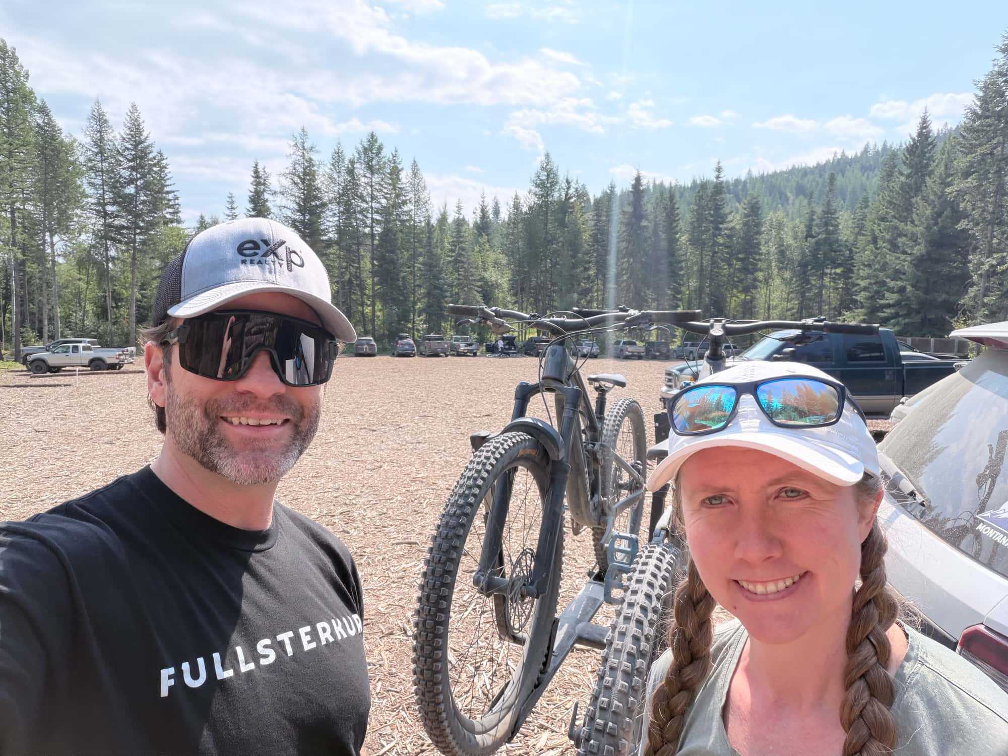 A mountain bike on a sunny dirt trail through open forest.